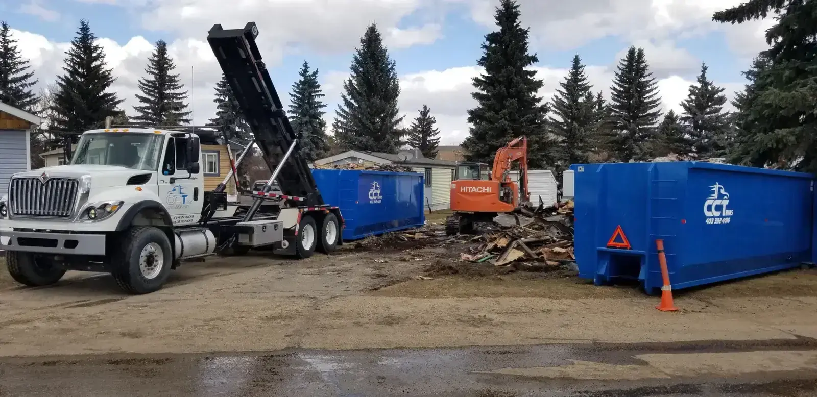 CCT Bins delivery truck placing dumpster on construction site - Alberta bin rental specialists